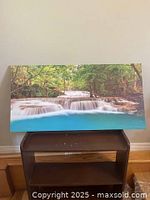 Front view of the framed canvas wall art showing the waterfall landscape and surrounding forest in vibrant detail.