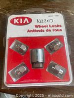 Original sealed Kia wheel locks package containing four wheel lock nuts and one key socket with instructions