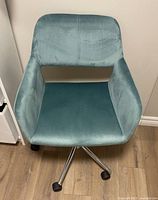 Top view of a light blue velvet office chair showing the seat and backrest upholstery and armrests.