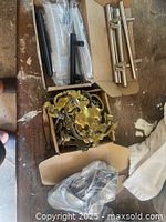 Photo showing three boxes containing assorted drawer handles and pulls in stainless steel and antique brass finishes.