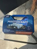 Front view of the Mastercraft 17-piece bi-metal hole saw set in carrying case on glass table, showing product branding and overall packaging.