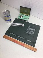 Full lot with book, aluminum ingot, speed wrench set, can, and wooden ruler arranged on white background