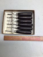 Set of six Lee Valley carving tools with wooden handles in original box next to a ruler for size reference.