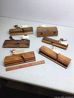 Overview of all six wooden molding planes laid out on table