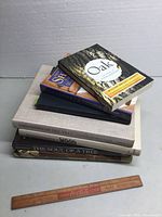 Stack of six woodworking and woodcraft books and a wooden Coca-Cola ruler placed on a flat surface.