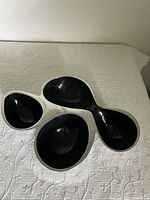 White base tray with four pod-shaped compartments, viewed from above on a white textured fabric.