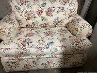 Close-up view of the front and side of the Bassett large chair and a half showing floral upholstery and condition.