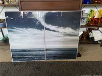 Two large framed ocean pictures showing ocean under cloudy skies. Photos are professional quality and framed identically. The frames appear to be well constructed with a thin border.