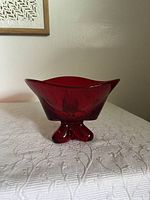Side view of the ruby red Viking glass bowl showing the three-sided design and the three rounded footed supports.