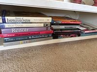 Stack of art coffee table books including Masters of Impressionism, Van Gogh, Renoir, Norman Rockwell, Barbra Streisand design book, and Picasso.