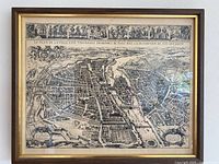 Framed Merian map of Paris from 1615 showing bird's eye view of city with detailed street and landmark depictions in black and white.