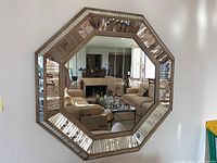 Front view of the octagonal mirror mounted on wall, showing wood frame and mirrored beveled edge.