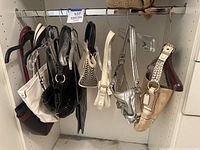 View of 8 assorted leather purses hanging on hangers inside a closet rack showing variety of styles including woven details and tote styles.