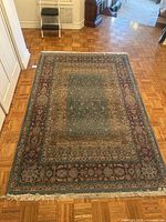 Full view of the Old Masters Collection Oriental Weavers rug laid out on hardwood flooring. Shows detailed pattern of floral and medallion design with fringes on ends and evidence of light wear on edges.