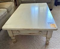 Front view showing one side with two drawers and round wooden knobs, cream shabby chic finish, and turned legs.