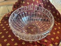 Clear crystal bowl viewed from above, showing ribbed interior and Roman numeral rim detail.