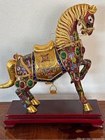 Full side view of the vintage Chinese cloisonne horse showing colorful enamel, golden accents, and green stone inlays on a wooden base.