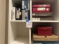 Shelf containing multiple women's shoe and boot boxes from Munro, Skechers, and Enzo Angeline, showing variety of original boxes.