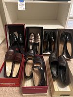 Overview of seven pairs of women's casual flats in boxes, mostly black or brown, size 7.5.
