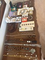Full view of all costume jewelry items including necklaces, bracelets, earrings, button covers, and watches.