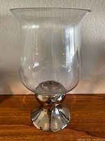Full view of clear glass hurricane candle holder on chrome base