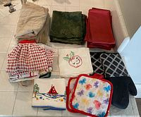 All items laid out: napkin stacks, towels, potholders, oven mitt