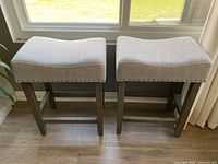 Pair of grey saddle counter stools front view