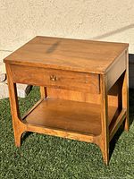 Front view of walnut Broyhill Brasilia end table showing drawer with brass pull and lower shelf