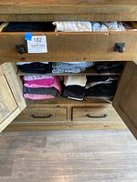 Two shelves of folded clothing including leggings and tops