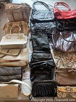 overview of twenty assorted handbags arranged on floor