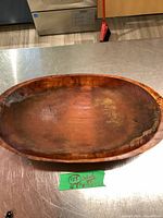 Top view of large oval wooden bowl showing size, wear and interior surface.