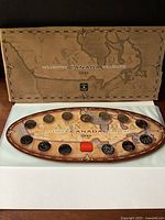 Full view of the unopened original display folder and the 13 coin set laid inside featuring vintage Canada map background.