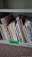 Books on a shelf showing titles and condition of the collection, including history and fiction books, some with visible minor wear on edges.