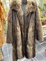 Full front view of brown full-length fur coat on hanger