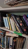 Books on top shelf showing assorted titles including 'The Return of King', 'Ladies Coupe' by Anita Nair, 'Surely You're Joking Mr. Feynman', 'The Big Book of Oceans', among others.