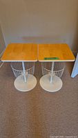 Pair of modern night stands with natural light wood square tops and white metal wire bases, shown from above.