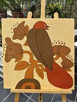 Front view of entire canvas print showing stylized bird and floral design on easel
