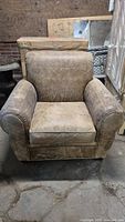 Front view of vintage distressed leather armchair showing full seat, back, and rolled arms.