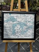 Front view of the framed Great Lakes map on an easel, showing the entire map and frame.