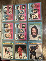 Photo showing front side of 11 hockey cards with pink top and blue bottom border, featuring Philadelphia Flyers, Los Angeles Kings, Chicago Black Hawks players.