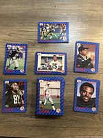 Top view of selected football trading cards including Rocket Ismail, Warren Moon, Harold Hallman, and a coach, plus a stack of cards showing card edges.