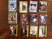Photo of multiple sports trading cards laid out, featuring basketball cards including Michael Jordan and others, cards arranged in rows with clear images of athletes playing sports.
