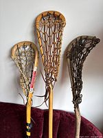 Another angle close-up showing wear and texture of the wood handles and leather netting on the sticks.