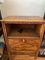 Front view of the vintage wooden side table showing drawer and open compartment with water staining