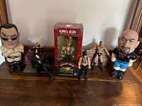 Full arranged lot showing all 7 items including bobbleheads and action figures on wooden surface