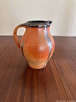 Front side view of the handcrafted pottery jug showing shape, color and handle