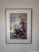 Front view of the framed watercolour floral painting hung on a white wall.