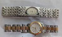 Two ladies' wristwatches side by side showing linked metal bands: one silver-tone, one silver/gold two-tone.