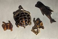 Four assorted pins/brooches including turtle, dolphin, insect/crab, and starfish commemorative pin.