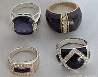 Top view of four fashion rings showing the stone settings and metal tones
